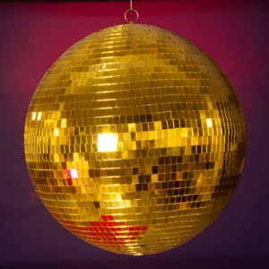 disco ball is a round object with a mirrored surface that reflects light in many directions, creating a complex display. The ball is usually pendent from the ceiling and rotates to cast reflected light on the surrounding surfaces. The surface of a disco ball is made up of hundreds or thousands of small, mirrored facets that are almost all the same size and shape When light reflects off these mirrors, it scatters in many directions, producing a unique effect. The rotation of the mirror globe creates a profusion of moving spots.