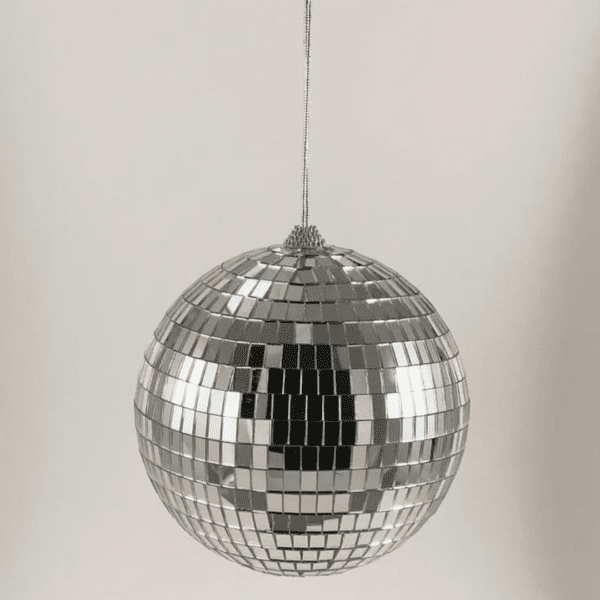 The hanging mirror ball surface is covered with tiny mirrored squares, which can reflect light on the room. Disco ball is a round object with a mirrored surface that reflects light in many directions, creating a complex display. The ball is usually pendent from the ceiling and rotates to cast reflected light on the surrounding surfaces. The surface of a disco ball is made up of hundreds or thousands of small, mirrored facets that are almost all the same size and shape. When light reflects off these mirrors, it scatters in many directions, producing a unique effect. The rotation of the mirror globe creates a profusion of moving spots.